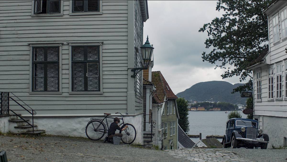 Comparison image showing a before and after of one of the VFX shots from the film. It shows the removal of modern elements and the addition of a ship in the background.