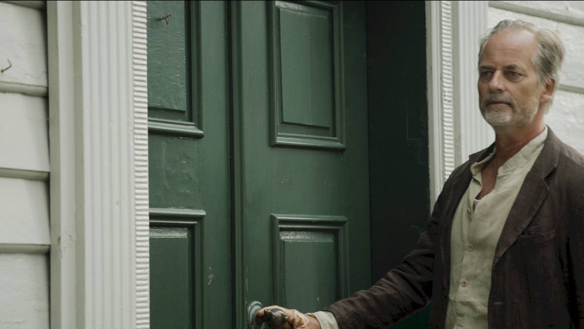 Comparison image showing a before and after of one of the VFX shots from the film. It shows the removal of a modern lock on the door.